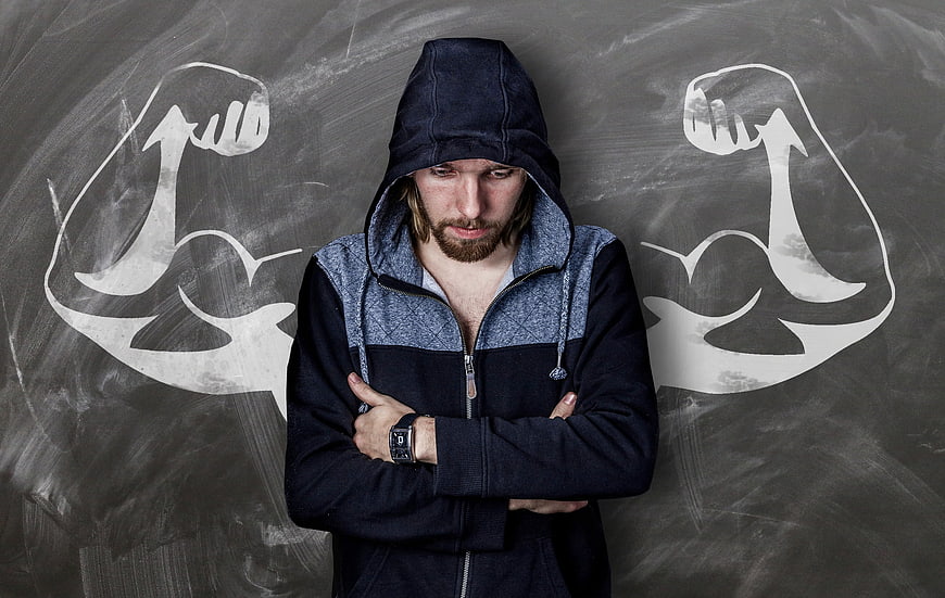 Disappointed man in hoodie with chalk muscle drawings