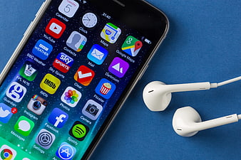 Smartphone with App Icons and White Earbuds on Blue Background