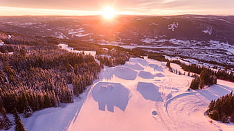 Aerial View of Snowy Ski Jump Hills at Golden Sunset