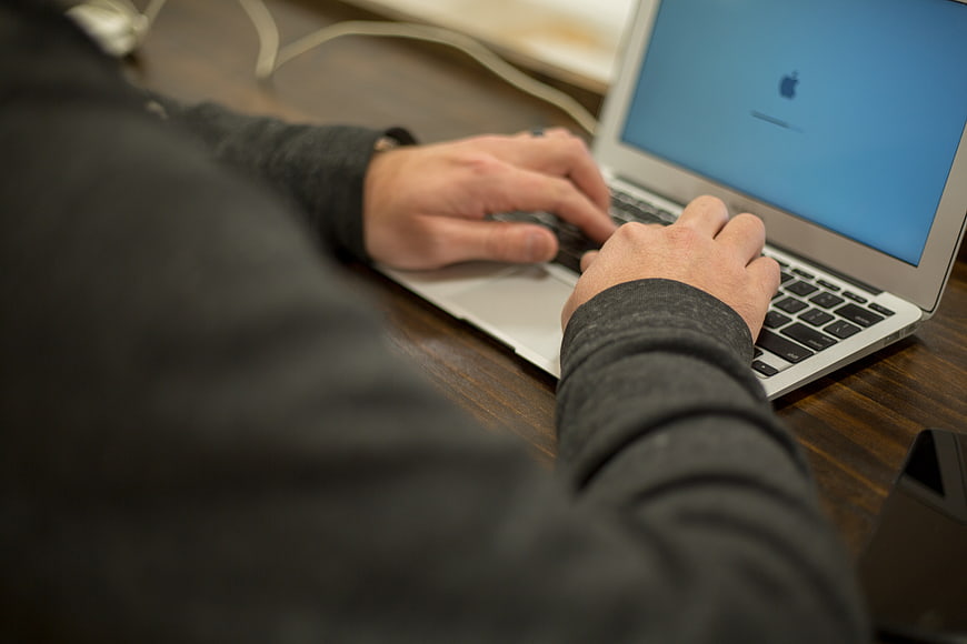 Close-up of hands typing on a laptop keyboard