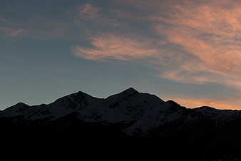 Snowy Mountain Silhouette Against Pink Sunset Sky