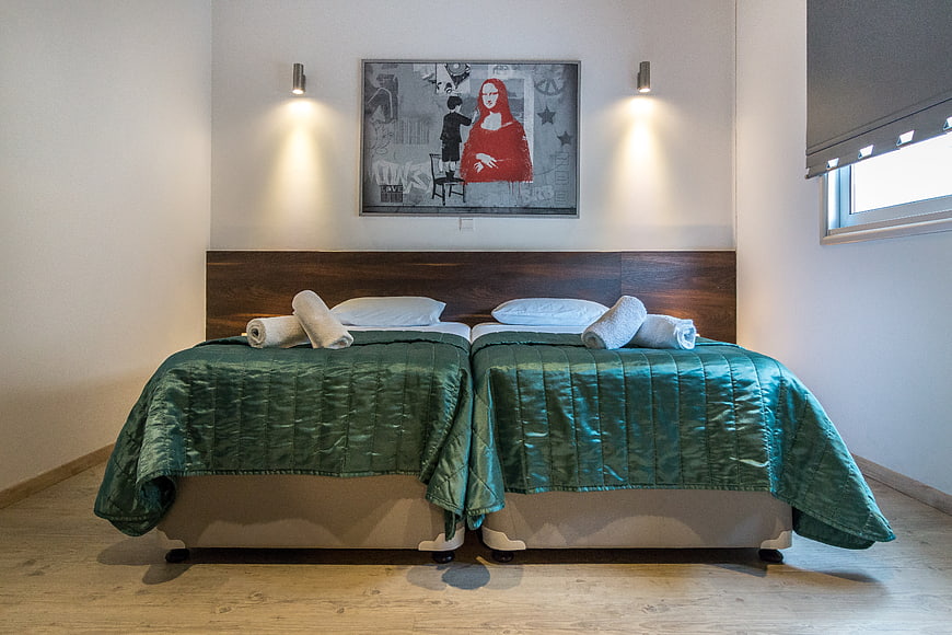 Modern Hotel Bedroom Interior With Twin Beds And Green Quilts