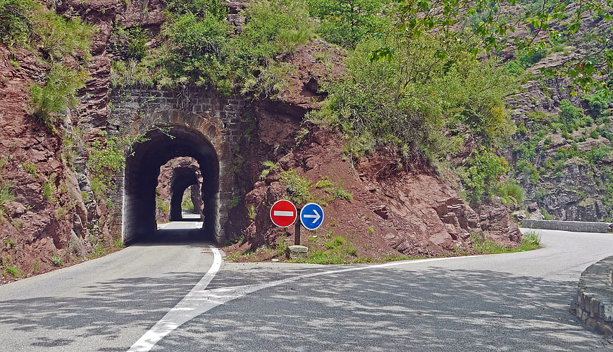 Mountain Road Fork with Stone Tunnel and Traffic Signs