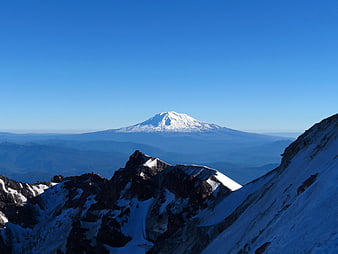 Snow-Capped Mountain Peak with Blue Sky and Rocky Foreground