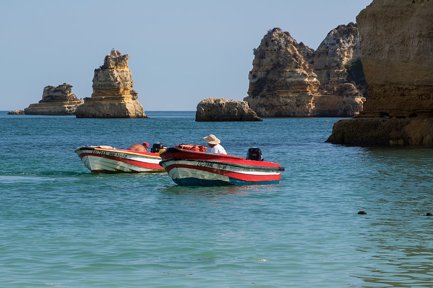 Traditional Fishing Boats Near Coastal Rock Formations