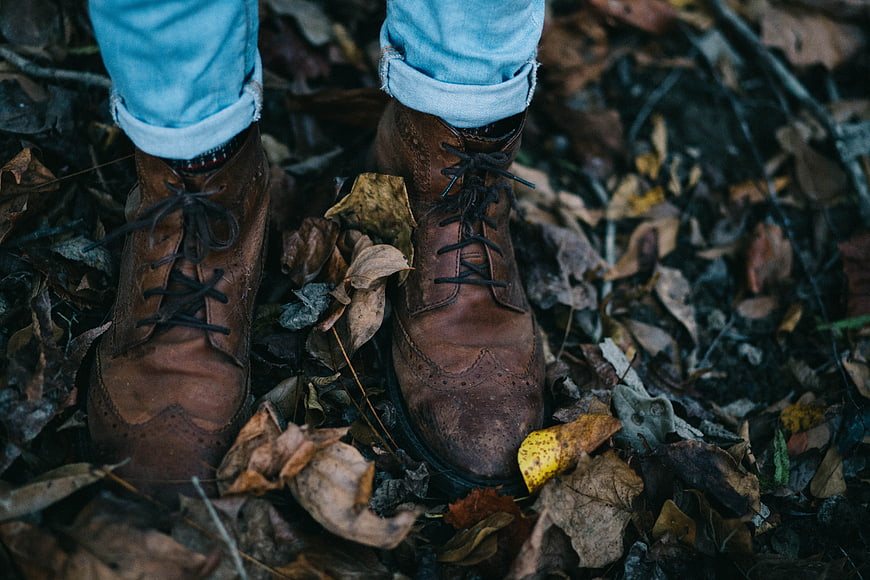 Brown leather boots on autumn leaves
