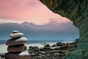 Stacked Zen Stones on Rocky Coast at Sunset