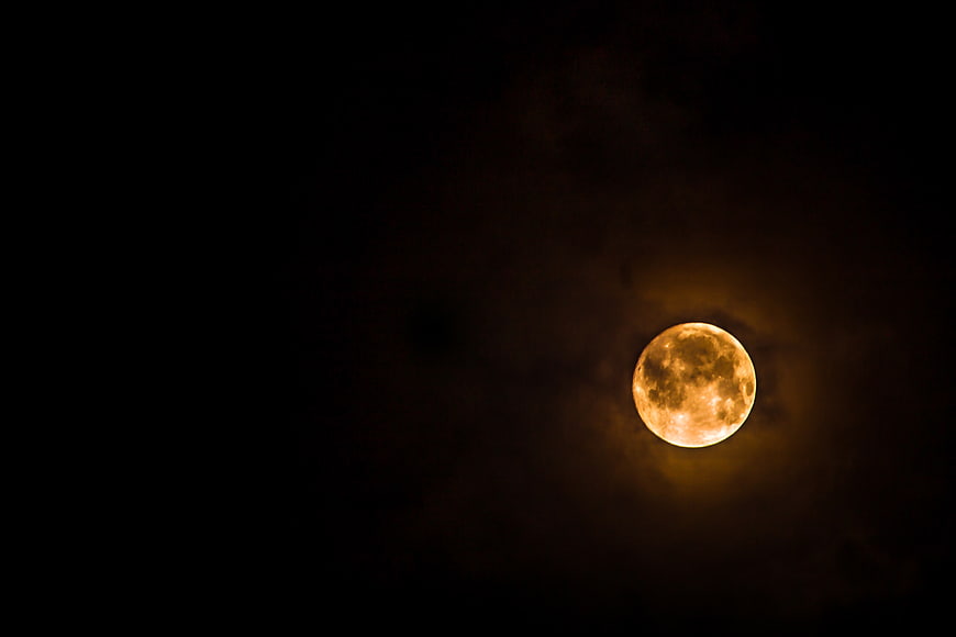 Full Orange Moon in Dark Night Sky with Clouds