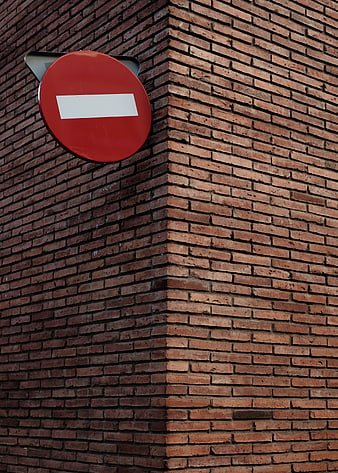 Red No Entry Sign on Textured Brick Wall Corner