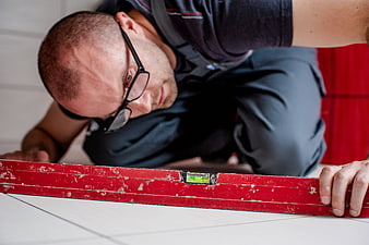 Male Tiler Checking Floor Level with Spirit Level