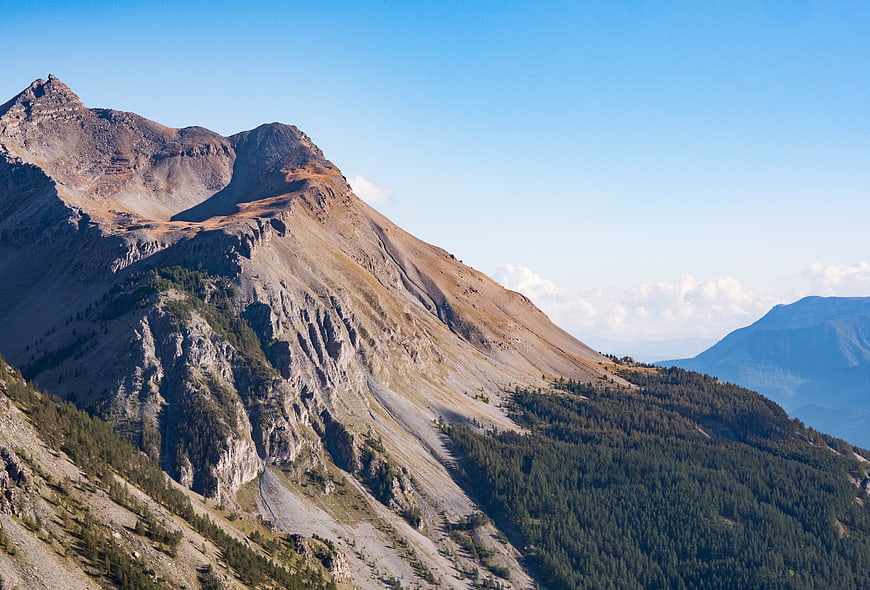 Majestic Mountain Peak with Forest Slope and Blue Sky