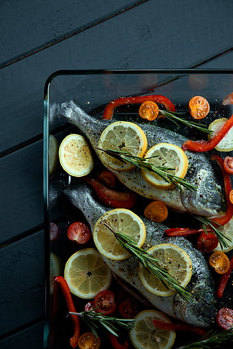 Raw Sea Bream Fish with Lemon and Rosemary in Glass Dish