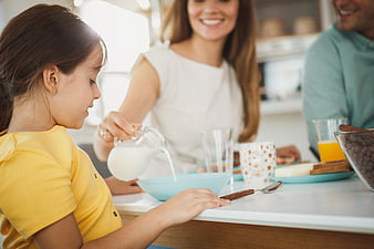 Happy Family Eating Breakfast Together in Kitchen