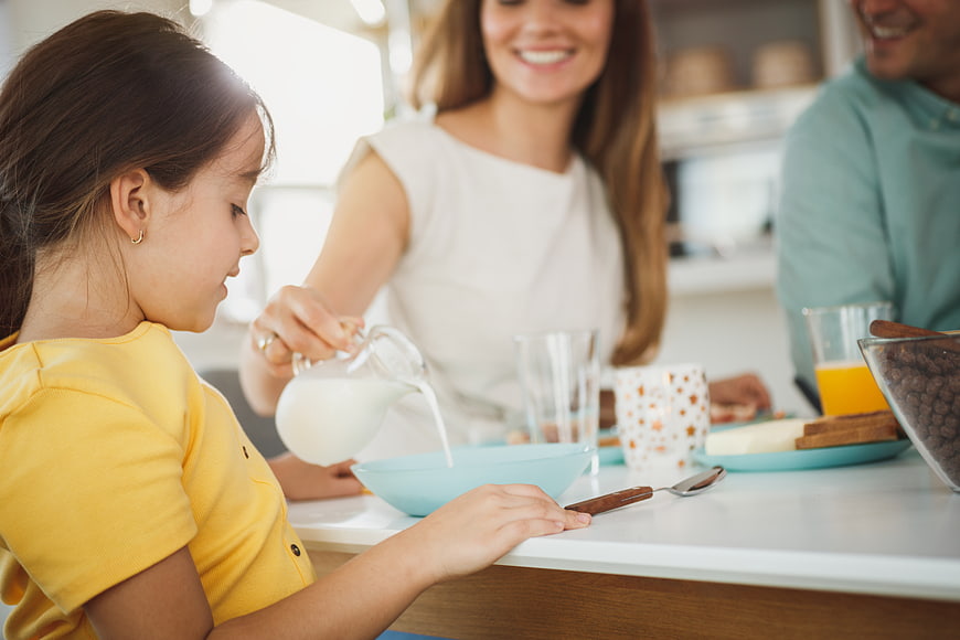 Happy Family Eating Breakfast Together in Kitchen