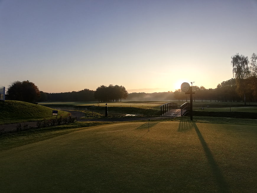 Serene Sunrise Over Golf Course with Wooden Bridge