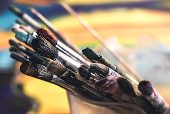 Close-up of used paintbrushes with colorful bristles