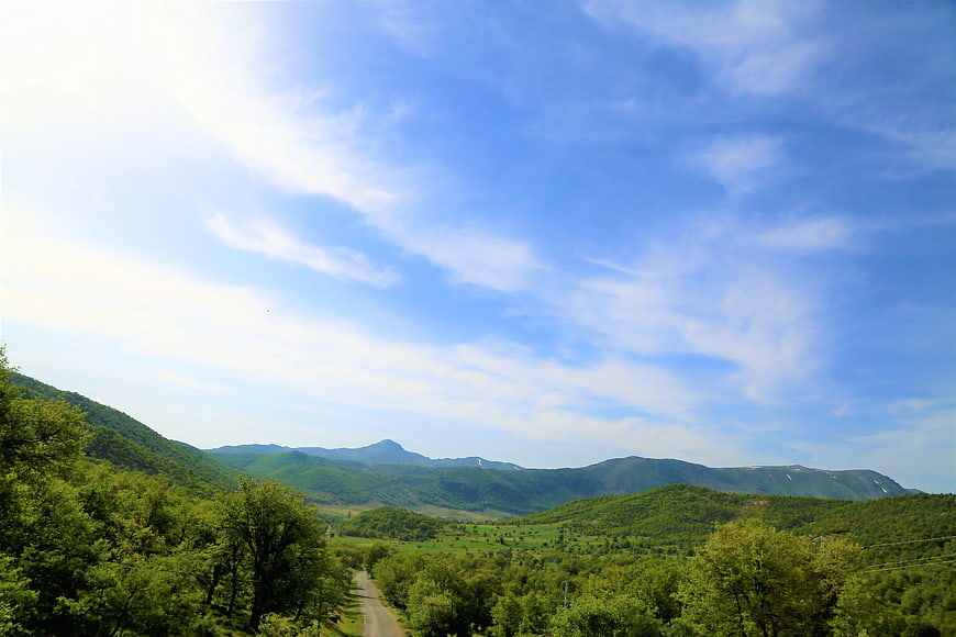 Scenic Green Mountain Landscape with Blue Sky and Winding Road