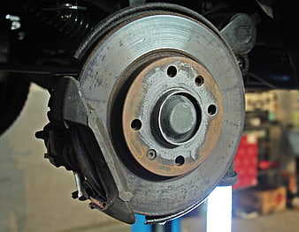 Close-up of car brake disc and caliper in auto repair shop