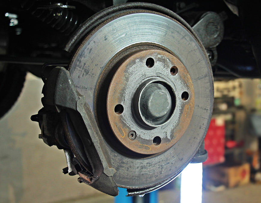 Close-up of car brake disc and caliper in auto repair shop