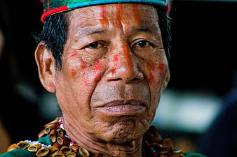 Close-up portrait of an indigenous man with traditional red face paint