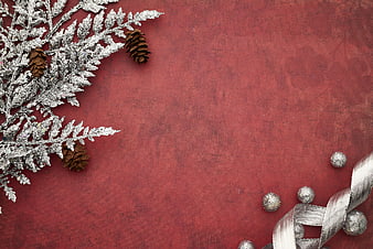 Frosted Pine Branches and Silver Ornaments on Red Background