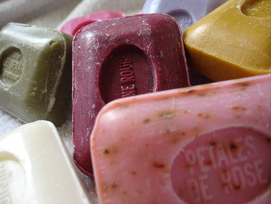 Close-up of colorful artisanal soap bars with botanical inclusions