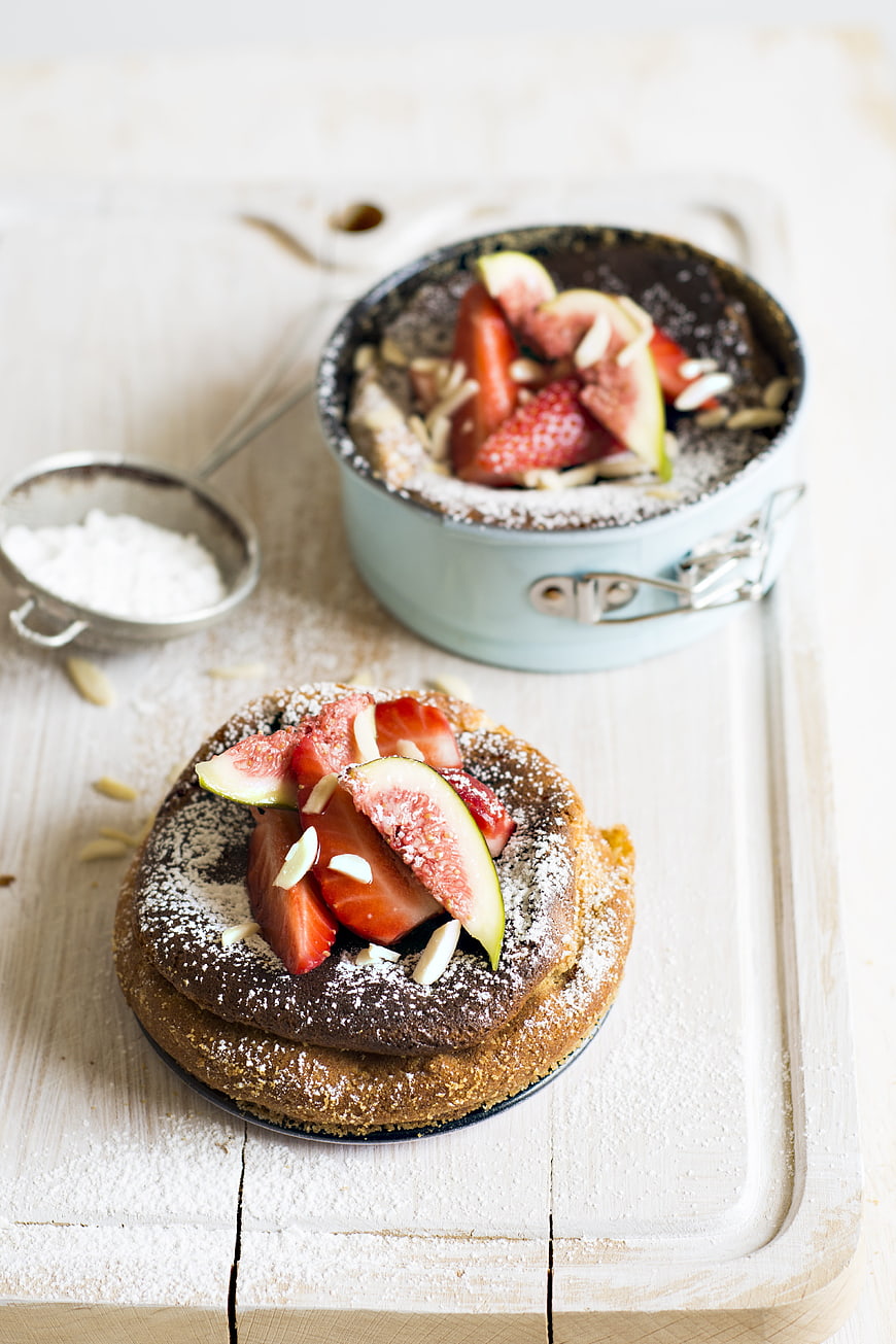 Chocolate cake with strawberries and figs on wooden board