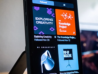 Smartphone displaying podcast app interface with colorful album art