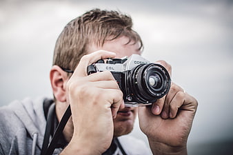 Photographer holding vintage Cosina SLR camera
