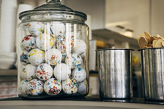 Glass Jar of Colorful Paint Splatter Spheres on Counter