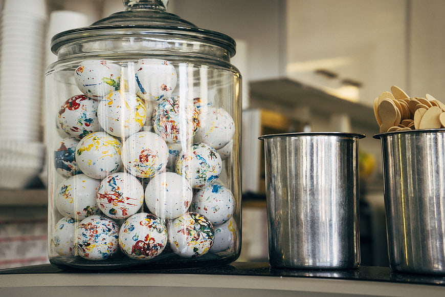 Glass Jar of Colorful Paint Splatter Spheres on Counter