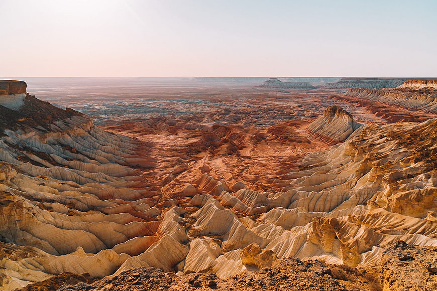 Vast desert landscape with eroded badlands and colorful rock formations