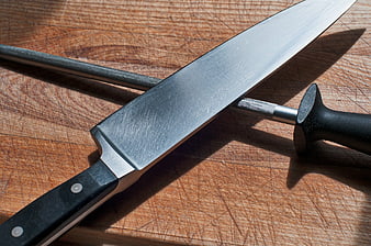 Chef Knife and Honing Steel on Worn Wooden Cutting Board
