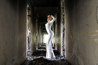Woman in White Bodycon Dress in Abandoned Corridor