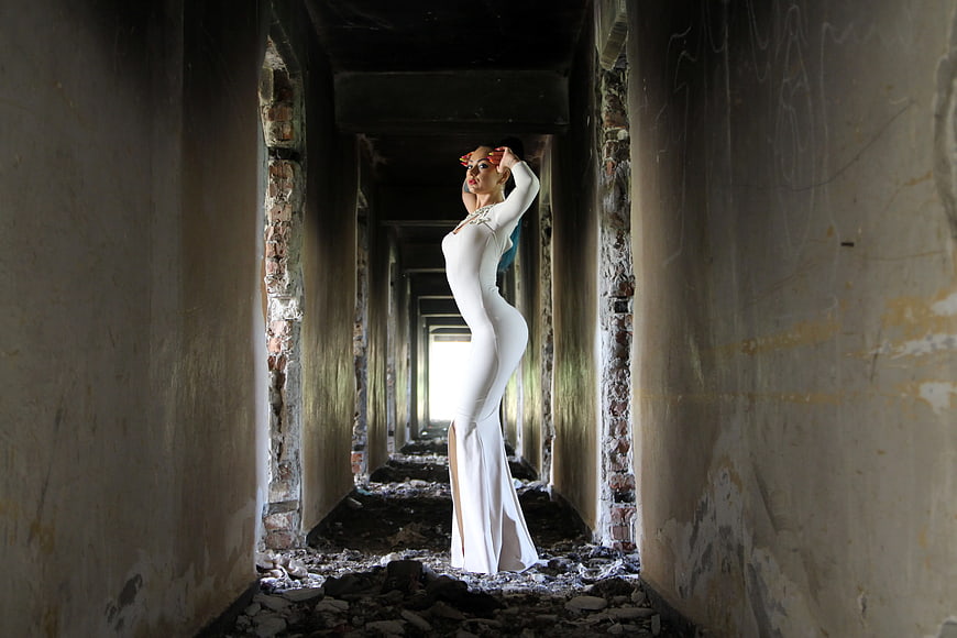 Woman in White Bodycon Dress in Abandoned Corridor