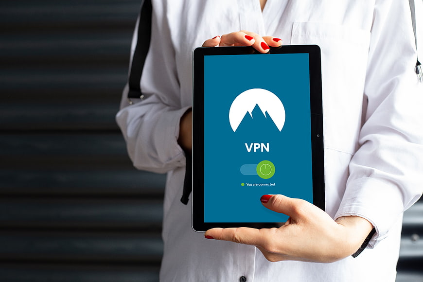 Person holding tablet with VPN security app interface