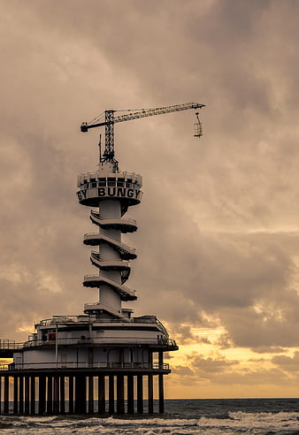 White Spiral Tower on Pier with Crane at Sunset