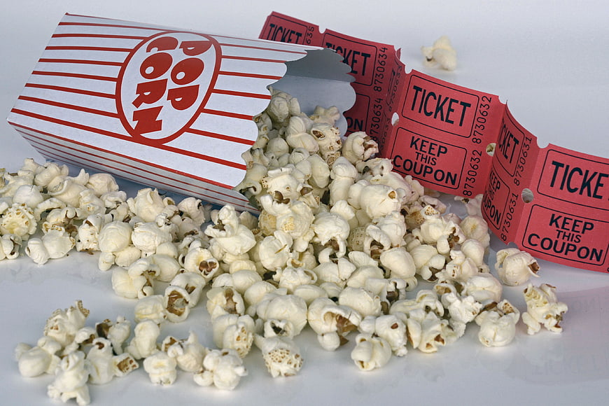 Spilled Popcorn Box and Movie Tickets on White Background