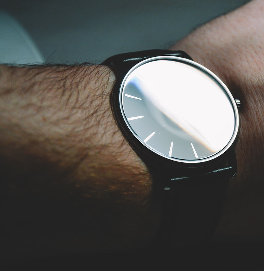Close-up of minimalist black watch on hairy wrist