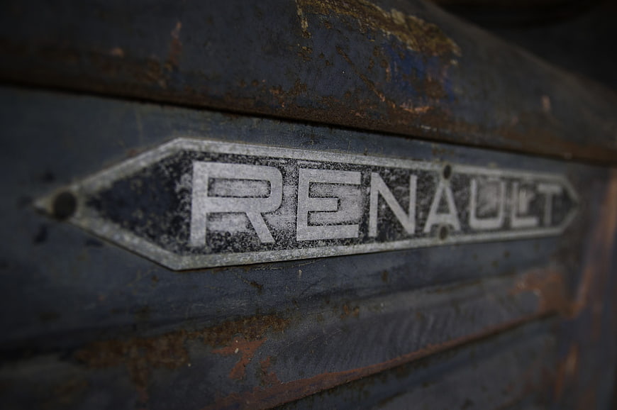 Close-up of rusty vintage Renault emblem on old car