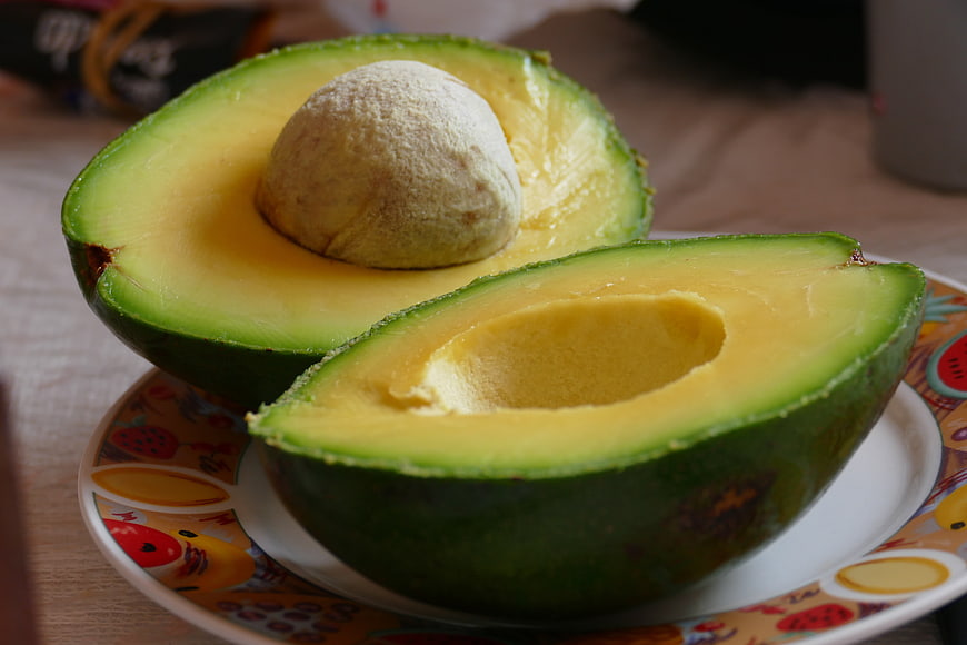 Fresh Halved Avocado With Seed On Decorative Plate