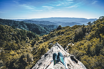 First-person view of hiker's feet on mountain peak