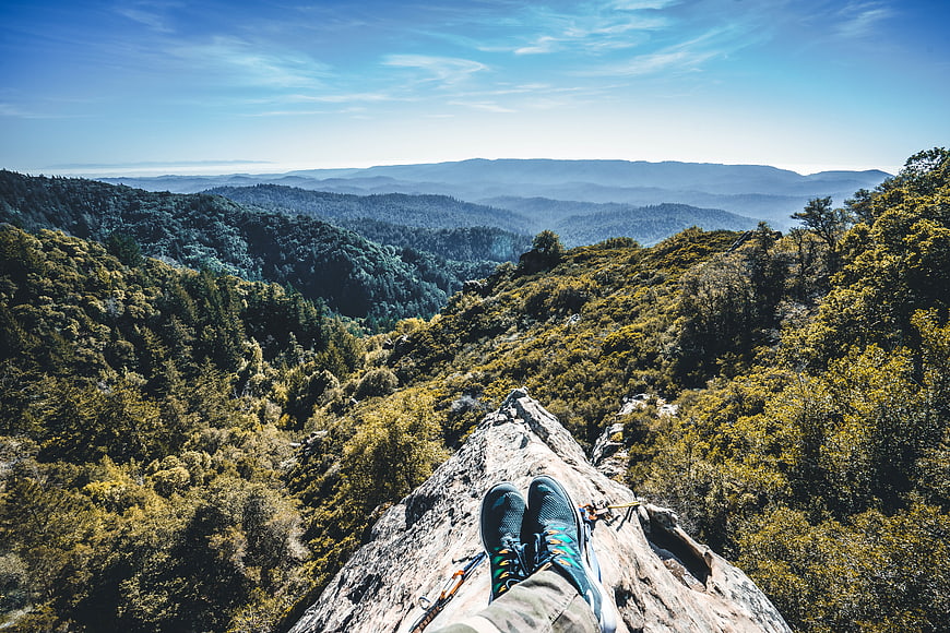 First-person view of hiker's feet on mountain peak