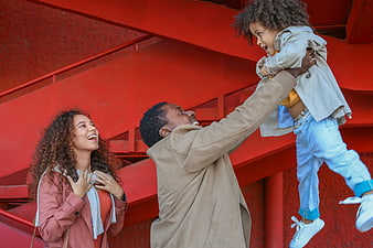 Happy African American Family Playing Outdoors Against Red Wall