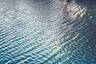 Sparkling blue ocean water surface with sunlight reflection
