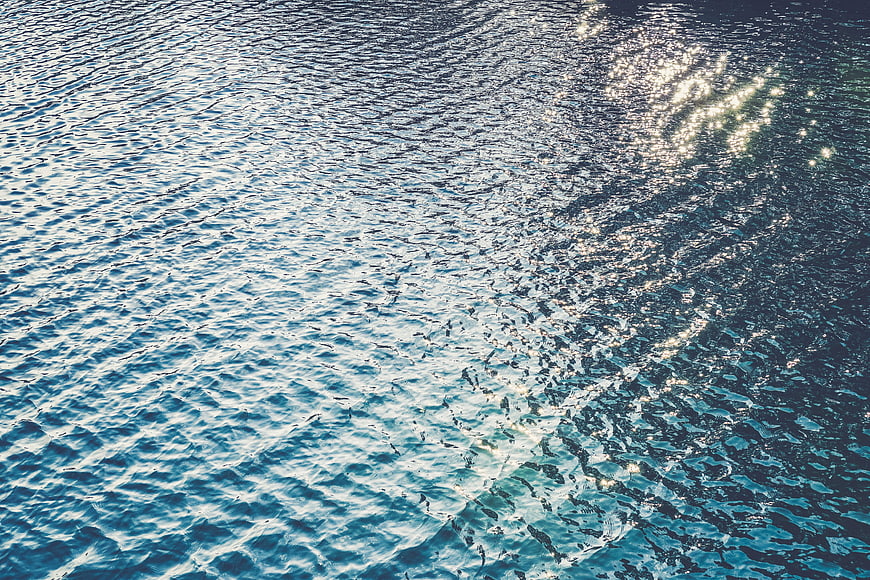 Sparkling blue ocean water surface with sunlight reflection