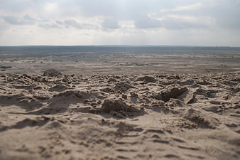 Low angle view of textured brown sand dunes in desert landscape