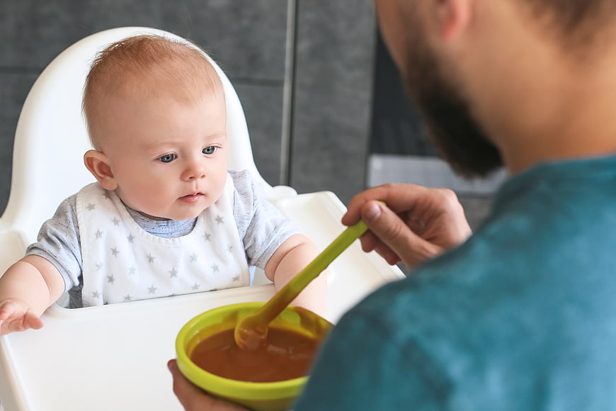 Father Feeding Baby Puree in High Chair