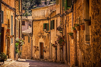 Sunlit narrow cobblestone street in old European village