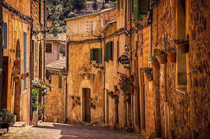 Sunlit narrow cobblestone street in old European village